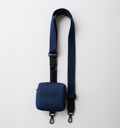 Adjustable shoulder strap for settle mat in navy with removable treat pouch.